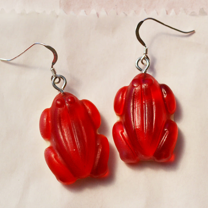 Close up of red frog lolly novelty earrings made from resin