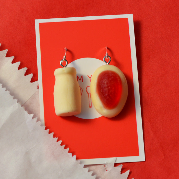 white milk bottle and red and white strawberry cream lolly novelty earrings made from resin against a red and white background