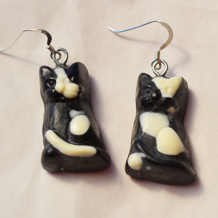 Black cat lolly novelty earrings made from resin with white spots on a white background