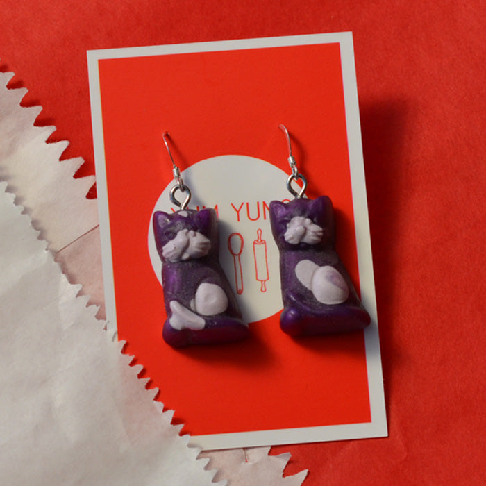 Purple lolly cat novelty earrings made from resinwith lilac spots on a red and white background