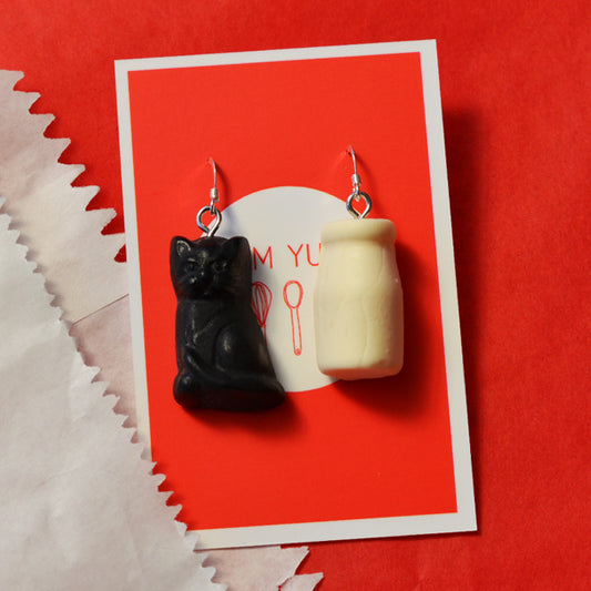 Black cat and milk bottle lolly red and white strawberry and cream lolly novelty earrings made from resin on a red and white background 